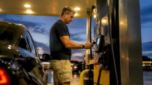 Man using smartphone to pay at gas pump