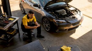 Auto technician holding ASE certification in garage