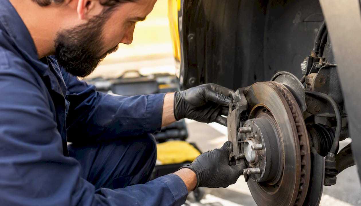 Mechanic inspecting car brake parts close-up