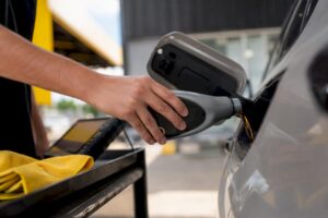 Hand pouring fuel system cleaner into vehicle gas tank