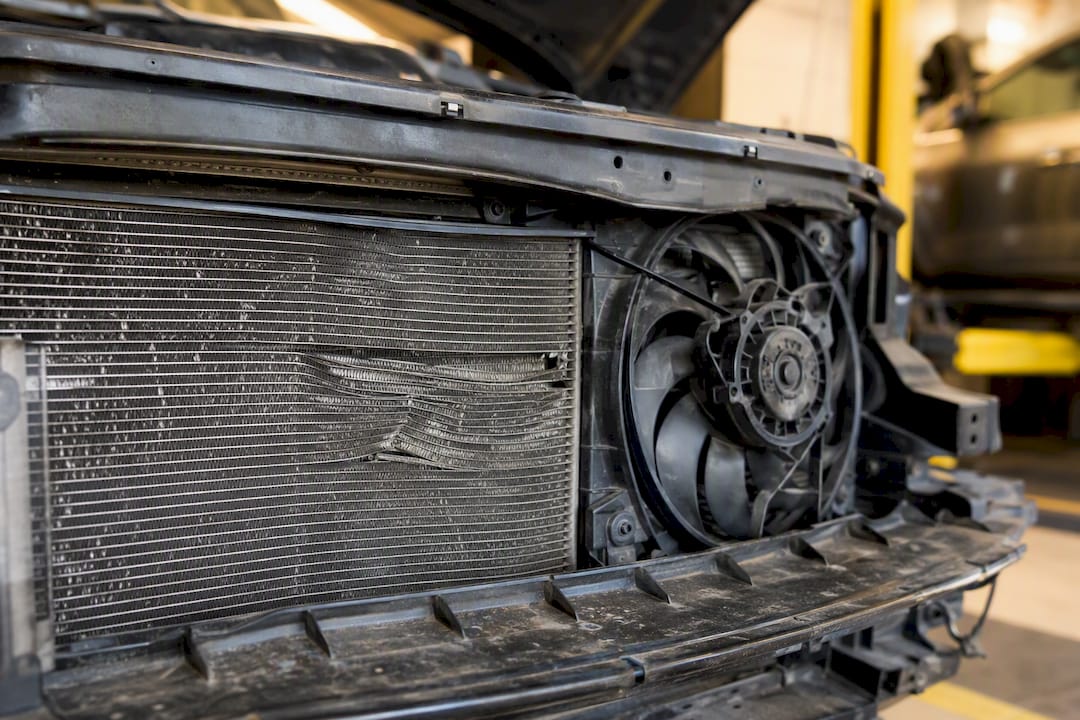 Close-up of bent condenser fins and cooling fan