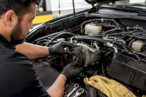 Mechanic inspecting car AC compressor clutch