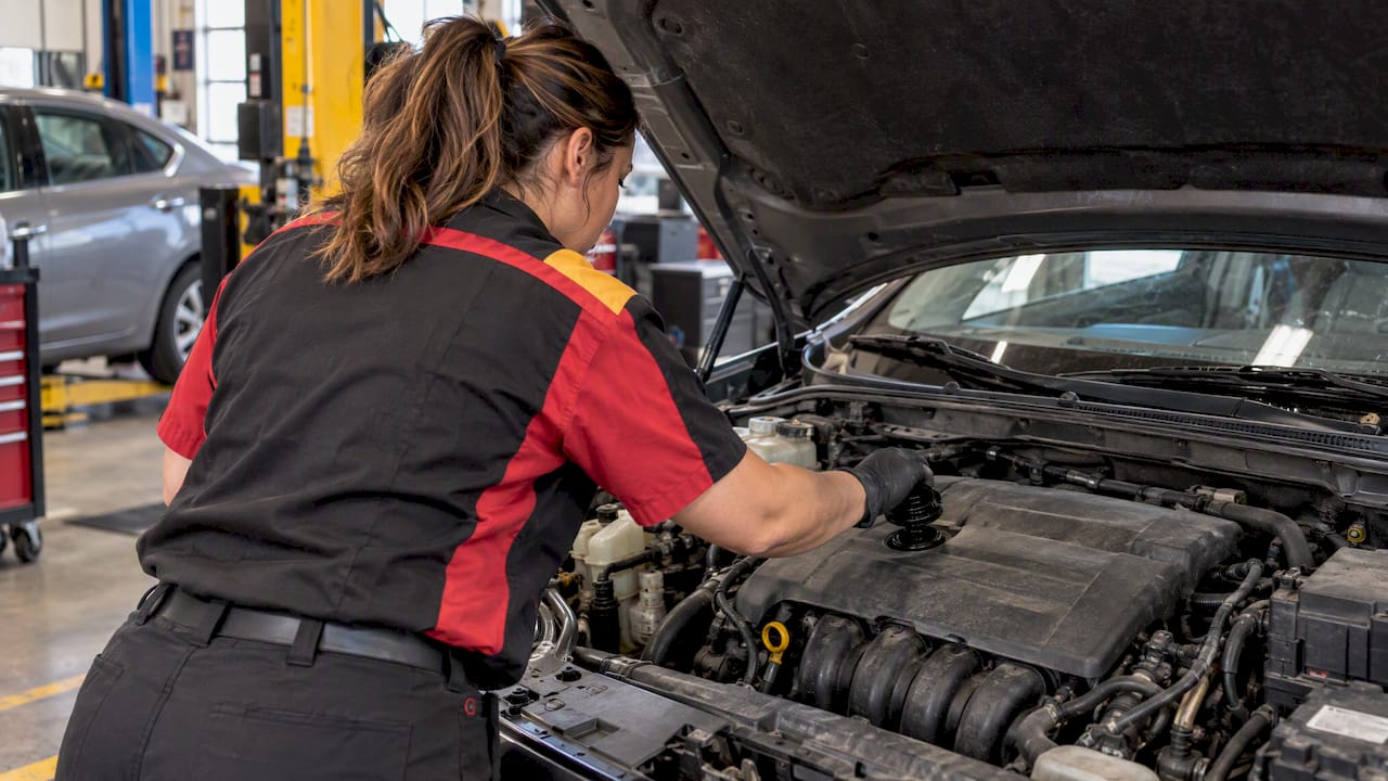 Technician checking vehicle oil filler cap