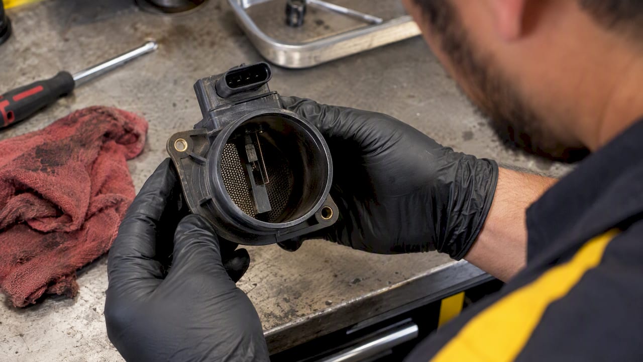 Technician checking mass air flow sensor wires